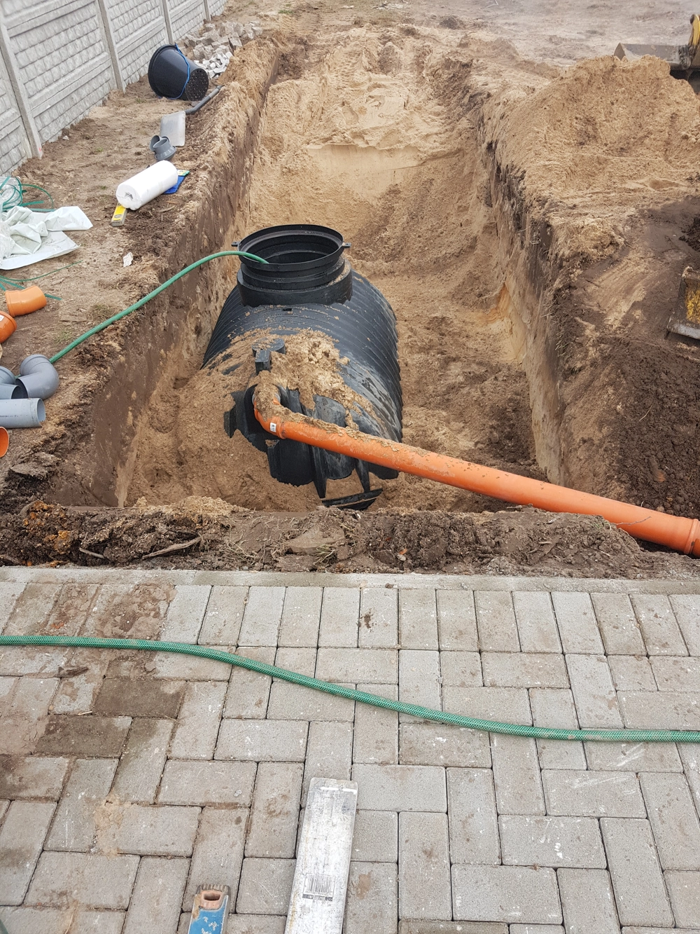 Montaż zbiornika na deszczówkę w wykopie z podłączeniem rurą kanalizacyjną