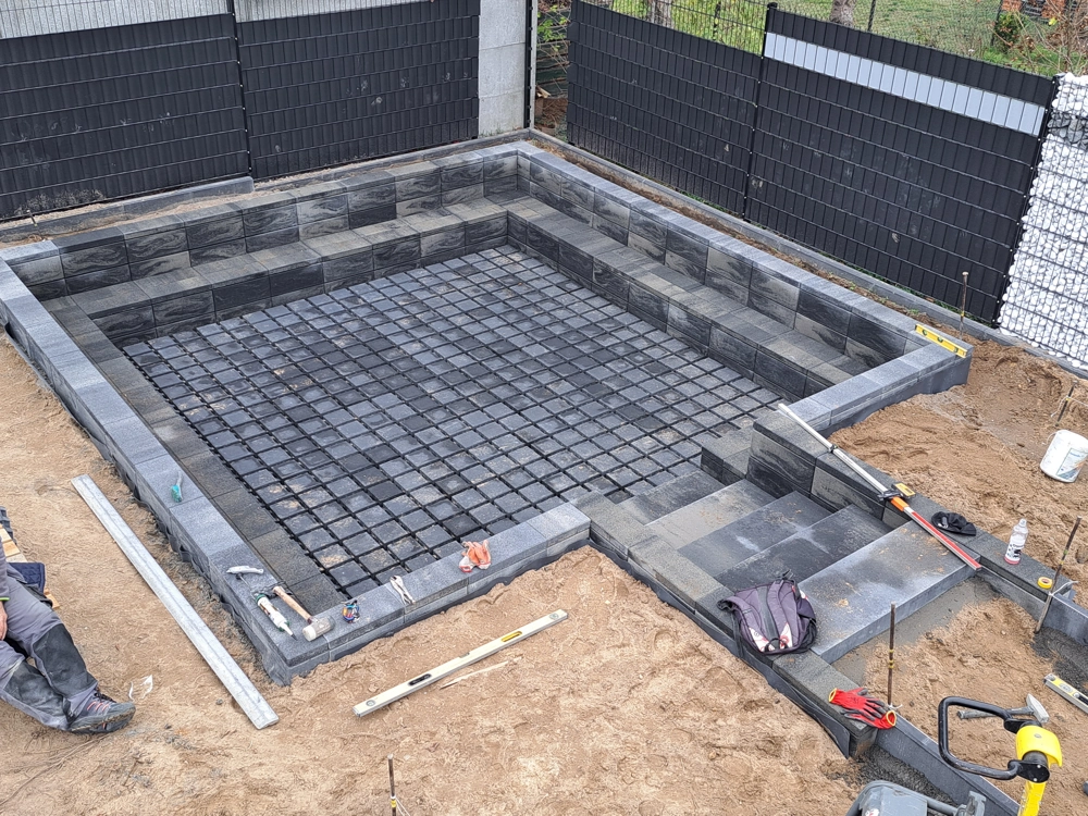 Podłoże pod układanie kostki brukowej z betonowymi obrzeżami i wstępną siatką nośną