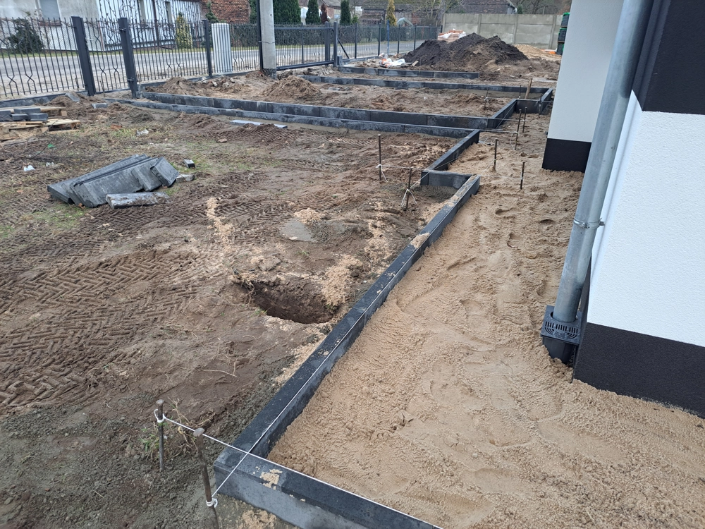 Opaska wokół domu z kostki – prace ziemne i niwelacja terenu z formami pod obrzeża