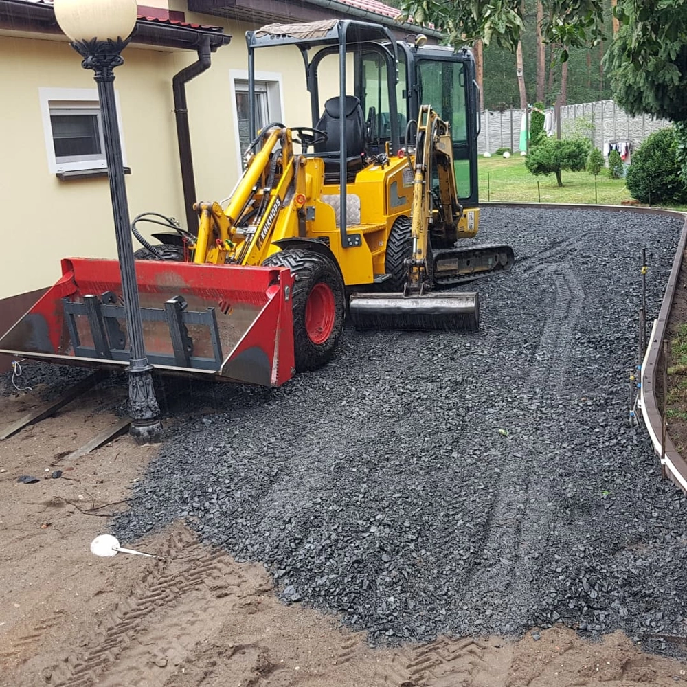 Ładowarka kołowa wykonująca niwelację terenu pod nawierzchnię z kruszywa