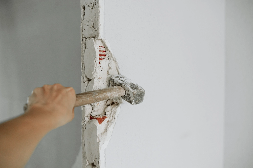 Demontaż fragmentu ściany betonowej młotem – Rozbiórki